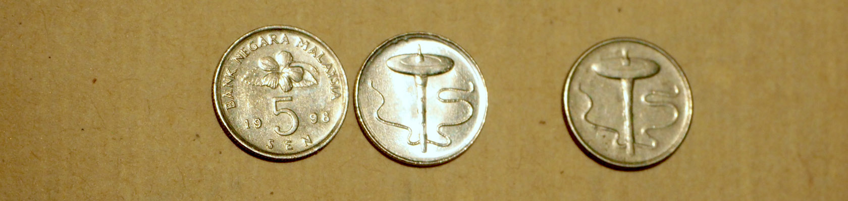 3 Münzen aus Malaysia, auf denen eine Kreisel abgebildet ist.